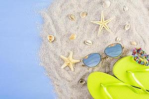fondo de verano. arena de mar con conchas, estrellas de mar y gafas de sol. concepto de vacaciones de verano foto