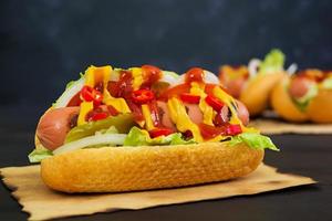 Delicious homemade hot dog on dark background photo