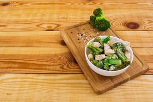 Chicken with broccoli on a wooden background photo