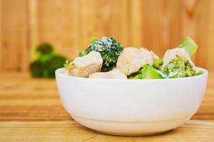 Chicken with broccoli on a wooden background photo