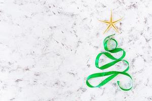 Christmas tree made of ribbon and starfish on white background. Top view photo