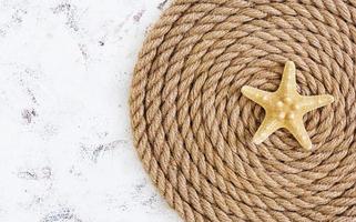 Rope and starfish on white background. Top view photo