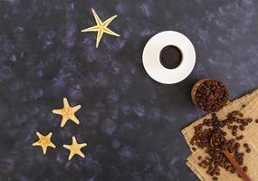 Coffee cup and coffee beans on dark background. Top view photo