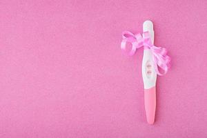 Positive pregnancy test isolated on pink background photo