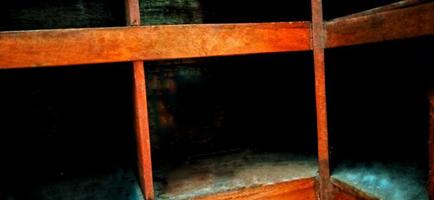 An old and dull red orange wooden locker under a dim background. photo