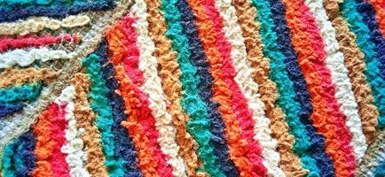 Variegated multicolor straight woven carpet texture. Fuzzy thin grunge vertical line textile material. Curly carpet rug fabric effect. photo