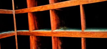 An old and dull red orange wooden locker under a dim background. photo