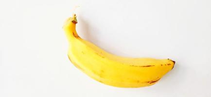 An isolated yellow ripe banana fruit on the gray background. Suitable for poster, backdrop, advertising, agriculture company and industry, etc. photo