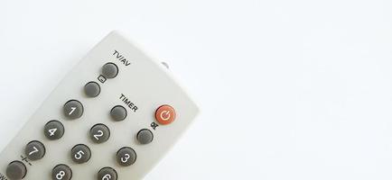 An isolated gray television remote control on the white gray background. Suitable for business, promotion, poster, backdrop, and advertising of company and industry. photo