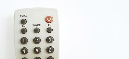 An isolated gray television remote control on the white gray background. Suitable for business, promotion, poster, backdrop, and advertising of company and industry. photo