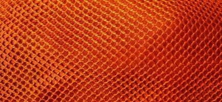 Gold orange honeycomb net patterns backgrpund. Synthetic honeycom net structure fabric background design. Available for text. Suitable for poster, backdrop, presentation, wallpaper, advertising, etc. photo