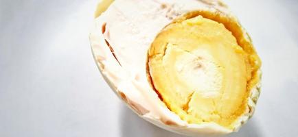 Indonesian food slice of salted egg or telur asin on the white gray plate background. Food ingredient background design. Suitable for advertising of food, drink, poster, backdrop, food company, etc. photo
