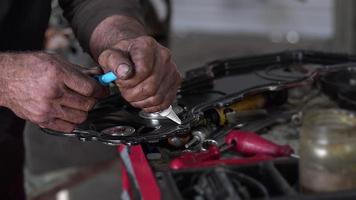 meccanico di auto che applica sigillante siliconico alla parte del motore nel filmato dell'officina. video