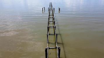 Fly over broken wooden bridge pier video