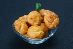 Sweet tasty profiteroles heap in the bowl photo