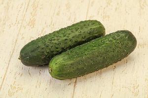 Green fresh cucumbers over background photo