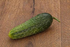 Green ripe fresh cucumber over background photo