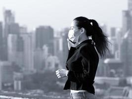 An Asian business woman talks on the phone through a mask to prevent dust pollution photo