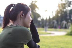 cara lateral de una mujer joven sentada en un parque. foto