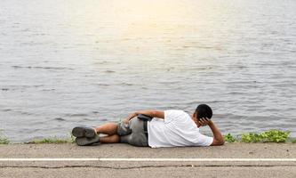 Men lying on the street near water waves. photo