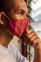 A red cloth mask on the face, looking through the louvers. photo