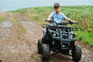 Boy drive four-wheller ATV quad bike. photo