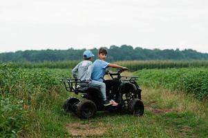 dos hermanos conduciendo quads de cuatro ruedas. momentos de niños felices. foto