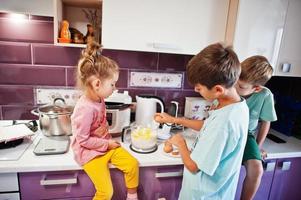 Kids cooking at kitchen, happy children's moments. Crack an egg. photo