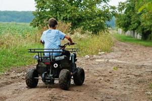 Boy drive four-wheller ATV quad bike. photo