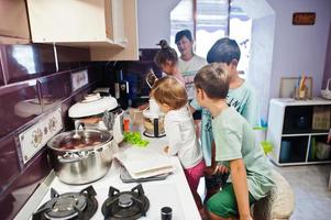 Mother with kids cooking at kitchen, happy children's moments. photo