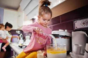 madre con hijos cocinando en la cocina, momentos felices de los niños. foto