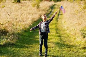 Little boy with USA flag outdoor. America celebrating. photo