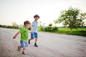 Two brothers walking holding hands, brother love. photo