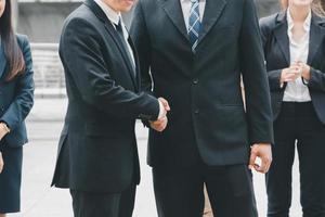 Success and Happiness concept, Business man handshake at outside office over blurred team background photo