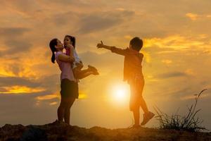 silueta de madre e hijo jugando en el fondo del atardecer de campo, concepto feliz de madre e hijo foto