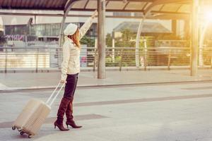 Businesswoman traveler with luggage at city background photo