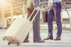 Businessman traveler with luggage at city background photo