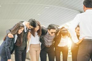 Group of Successful business team is hugging standing outside office people and teamwork concept photo