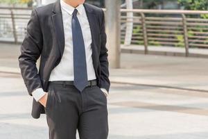 Young business man standing standing with hands in pocket over blurry background with copy space for concept picture. photo