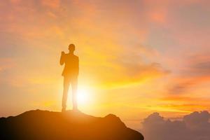 Silhouette of Business Engineer Man Celebration Success Happiness on a Stone Evening Sky Sunset Background, Sport and active life Concept with clipping path. photo