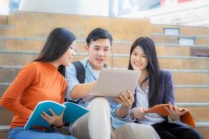 Close up of Happy high school students group are in attending of tutorial with notebook on the stair, education concept. photo