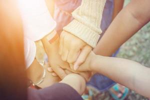 Success Teamwork Concept, Group of children joining hands blurred background photo