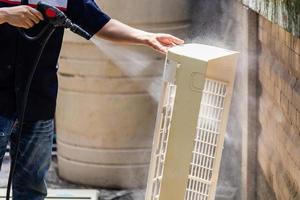 Male technician cleaning air conditioner indoors, Repairman washing dirty compartments air conditioner, Maintenance and repairing concepts photo