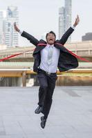 Success and Happiness concept, Cheerful business man crossing the finish line of racing track city background. photo