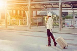 Businesswoman traveler with luggage at city background photo