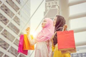 retrato de feliz hermosa joven mujer de negocios árabe con bolsas de compras, compras felices en el concepto de ciudad. foto