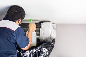 Repairman washing dirty compartments air conditioner, Male technician cleaning air conditioner indoors, Maintenance and repairing concepts photo