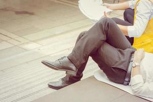 hombre de negocios e ingeniería de negocios relajándose acostado y sentado en el suelo después de trabajar duro. foto