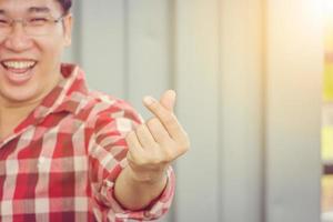 Close up of a man show finger heart symbol with copy space, message of love hand sign concept. photo