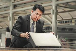 Close up of depressed businessman sitting on floor looking a suitcase, Failure and despair concept photo